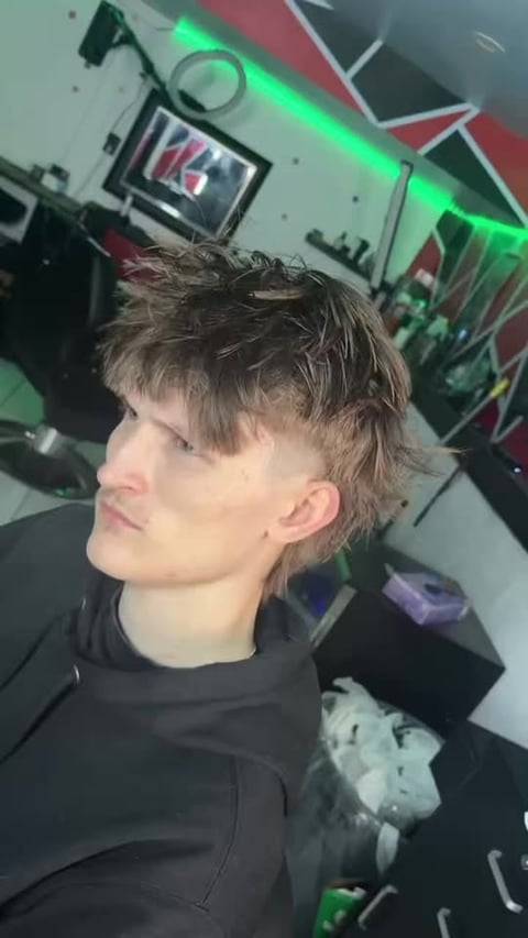 Side profile with short dark hair and undercut in neon lighting