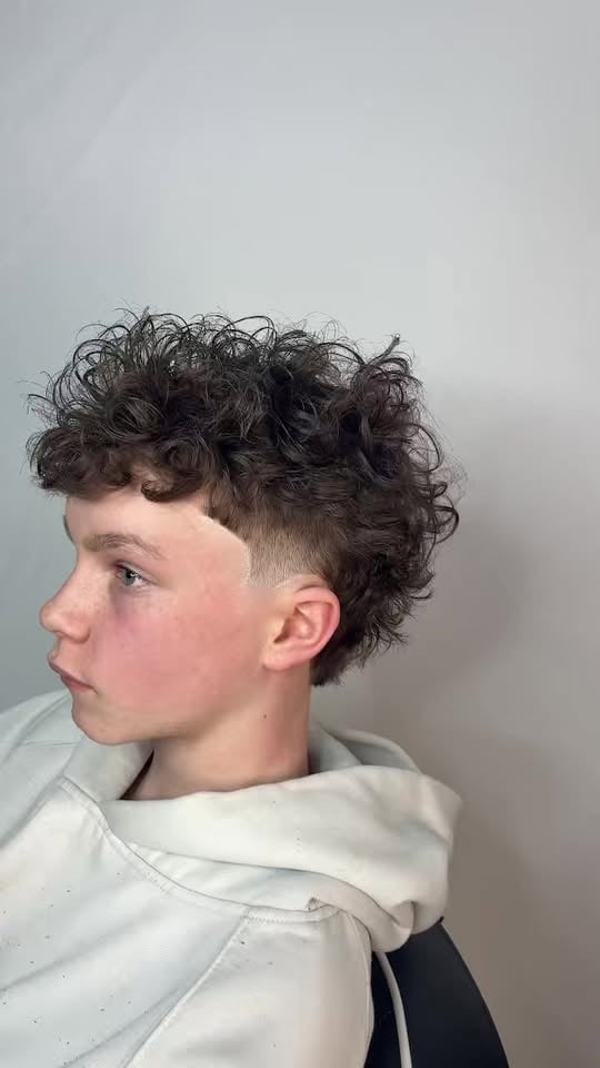 Young person with dark curly hair styled in a modern textured cut